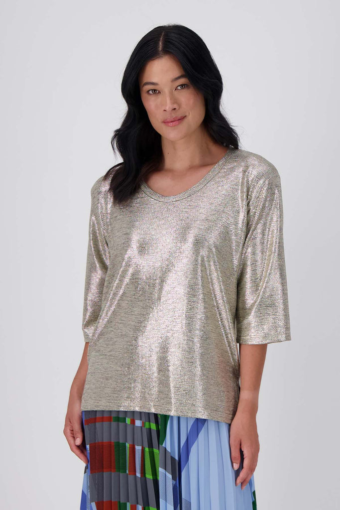 Olga de Polga Gold Prosecco top in metallic thread fabric. With a relaxed fit, scoop neckline, and 3/4 length sleeves, your everyday t-shirt now boasts a lustrous twist. Front close up view on model
