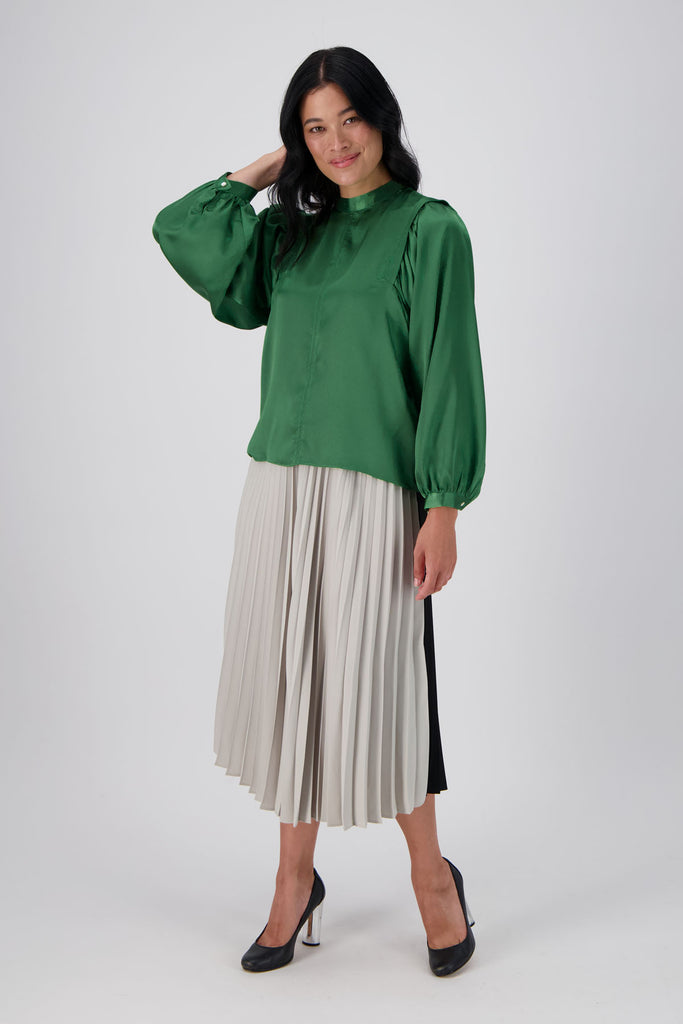 Olga de Polga Green Moonshine Blouse in satin. Billowing sleeves and a round neck make this the perfect blouse to dress up or down for any occasion. Front view worn with a skirt