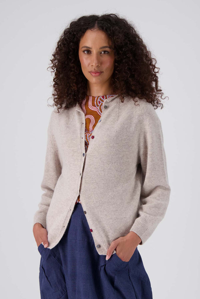 Ivory Olga de Polga Kyoto cardigan in a wool cashmere blend. With long sleeves and a round neckline this cardigan has a button down front with small, unique buttons. Front view on model