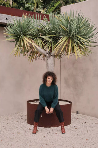Olga de Polga Teal Montreal sweater knit jumper, with a crew neckline and droped shoulders. This is our cosiest jumper every!  Front view, sitting.