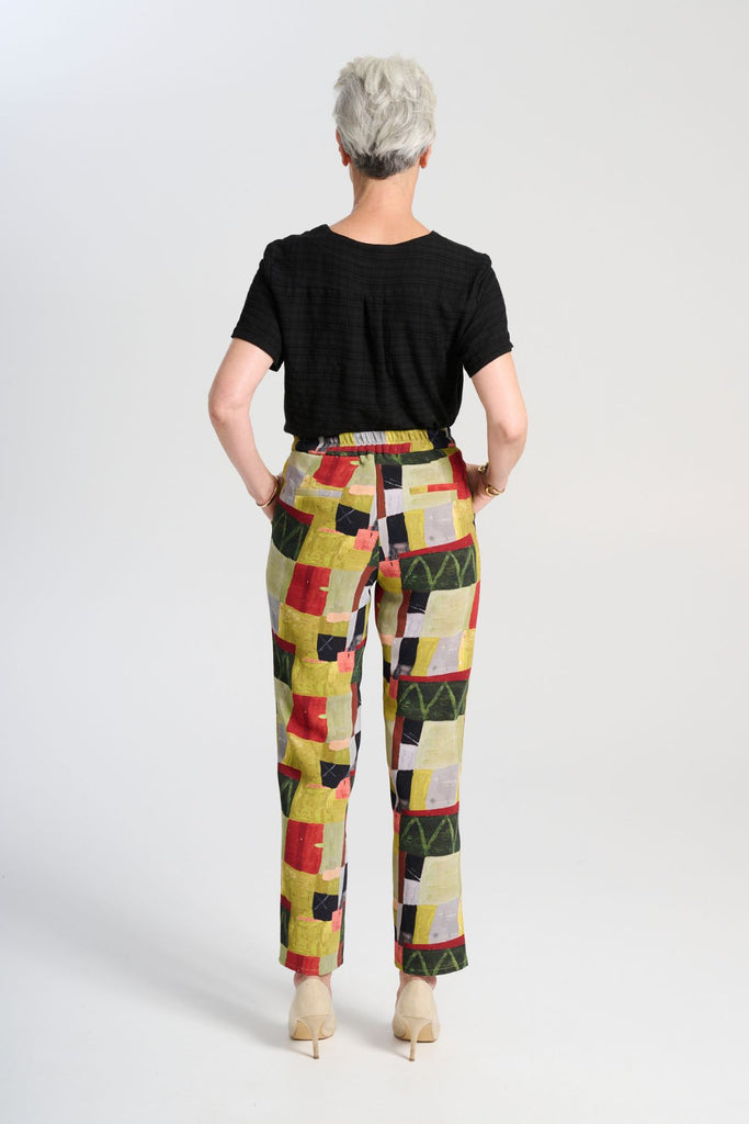 Olga de Polga green printed Pantalon pants in Kismet Sage. The Pantalon is a straight-legged pant that reaches the lower ankle, featuring a button and zip closure at the front with an elasticised back waistband for added comfort. Back view on model