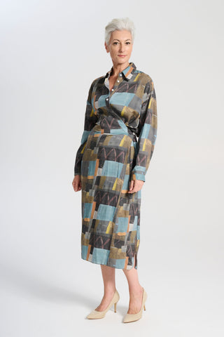 Olga de Polga Fluido dress in Azure Kismet soft wash Tencel fabric. A wrap shirt dress with long sleeves and a side split. Side front view on model