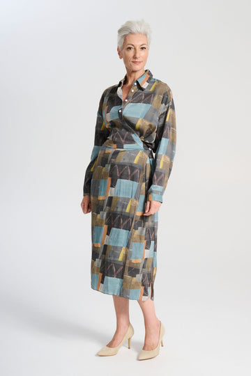 Olga de Polga Fluido dress in Azure Kismet soft wash Tencel fabric. A wrap shirt dress with long sleeves and a side split. Side front view on model