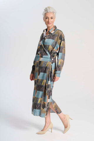 Olga de Polga Fluido dress in Azure Kismet soft wash Tencel fabric. A wrap shirt dress with long sleeves and a side split.  Side view on model
