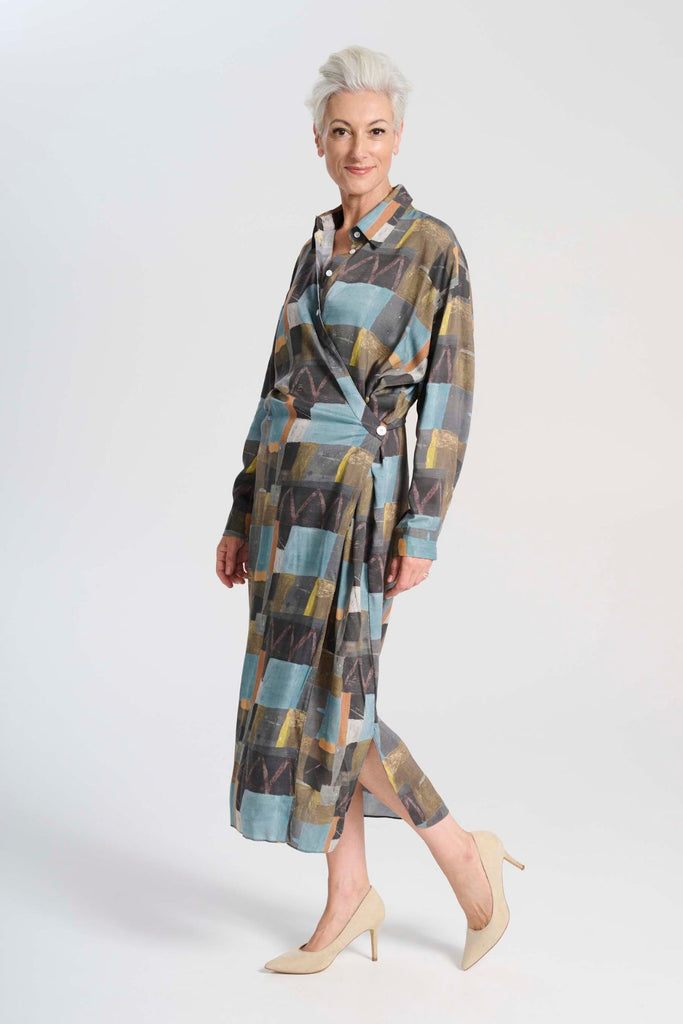 Olga de Polga Fluido dress in Azure Kismet soft wash Tencel fabric. A wrap shirt dress with long sleeves and a side split.  Side view on model