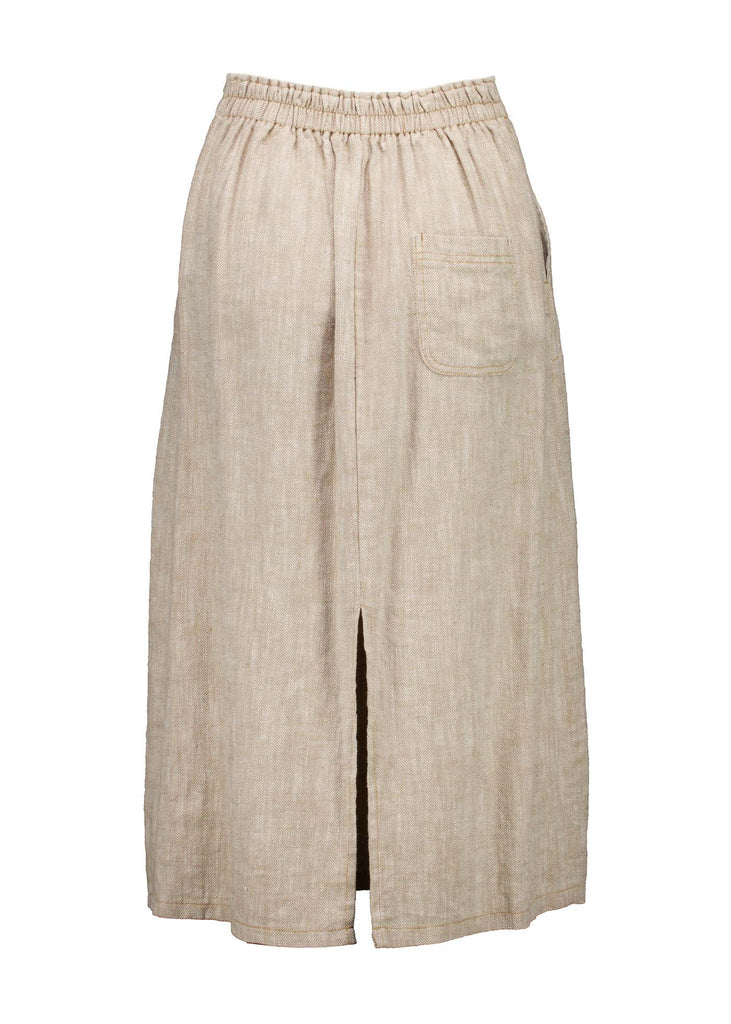 Olga de Polga Hepburn skirt in herringbone linen. Colour beige. Featuring a unique button detail at the waist that forms a flattering pocket shape, this skirt adds personality to any outfit. With an elasticated back waist for comfort, it finishes just below the knee and has a stylish back split for ease of movement. Back view.