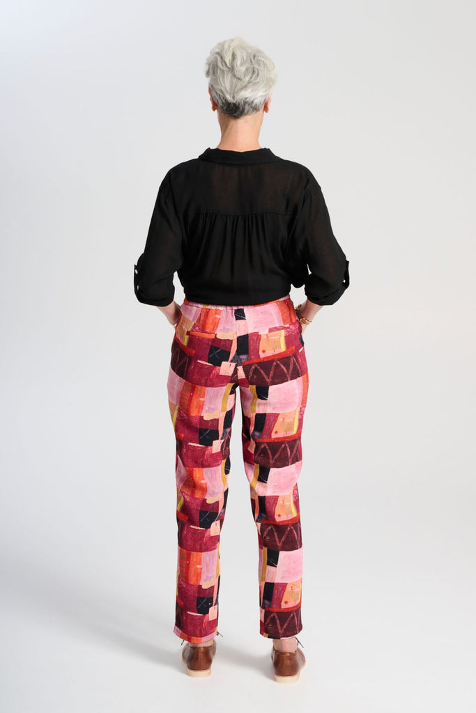 Olga de Polga Ava blouse in Black soft viscose crepe. Front button opening, shirt collar, adjustable sleeve length. Front patch pocket. Back view, tucked into trousers.