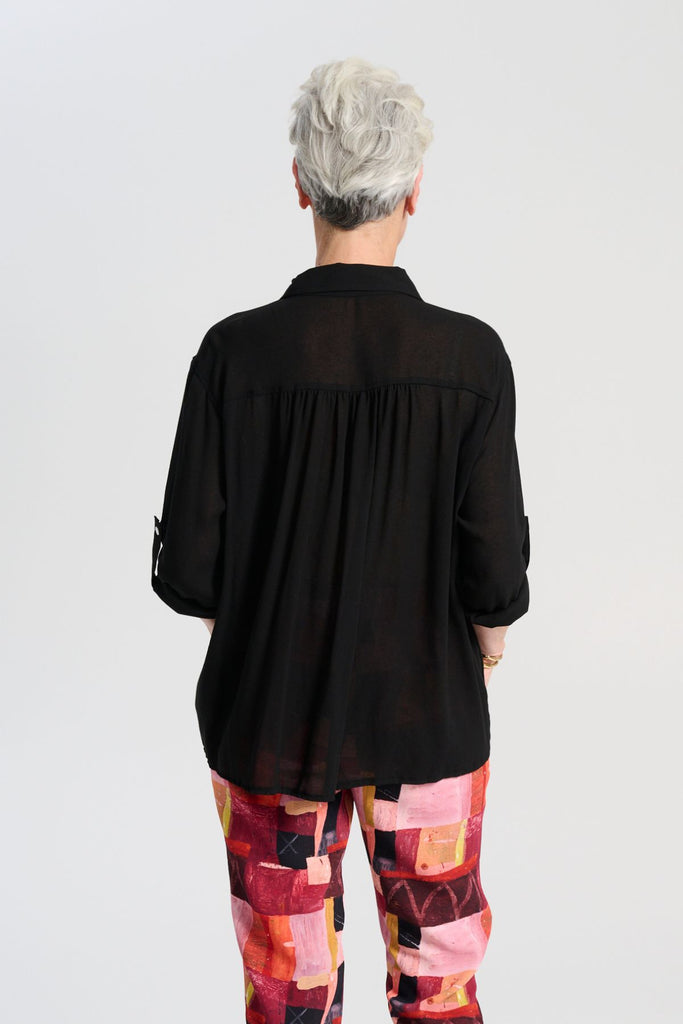 Olga de Polga Ava blouse in Black soft viscose crepe. Front button opening, shirt collar, adjustable sleeve length. Front patch pocket. Back view close-up