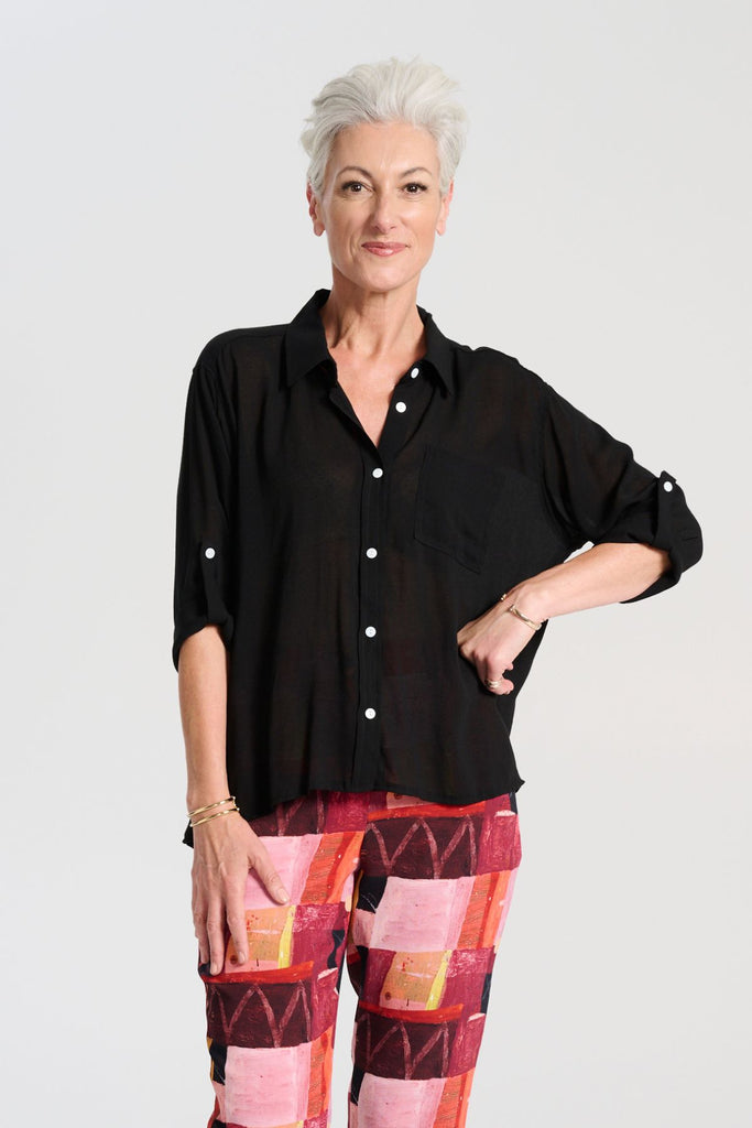 Olga de Polga Ava blouse in Black soft viscose crepe. Front button opening, shirt collar, adjustable sleeve length. Front patch pocket. Front close-up view