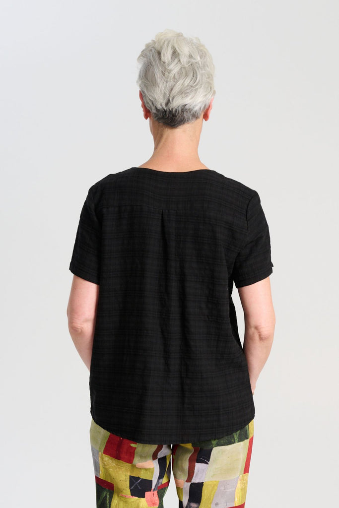Olga de Polga t-shirt classic top in black brushed cotton seersucker fabric with a subtle check. Short sleeves, round neckline and finishes at the hip. Back view on model