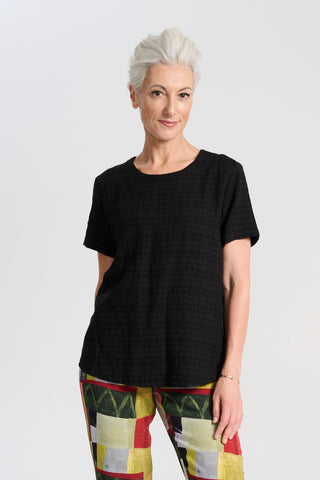Olga de Polga t-shirt classic top in black brushed cotton seersucker fabric with a subtle check. Short sleeves, round neckline and finishes at the hip. Front view on model.