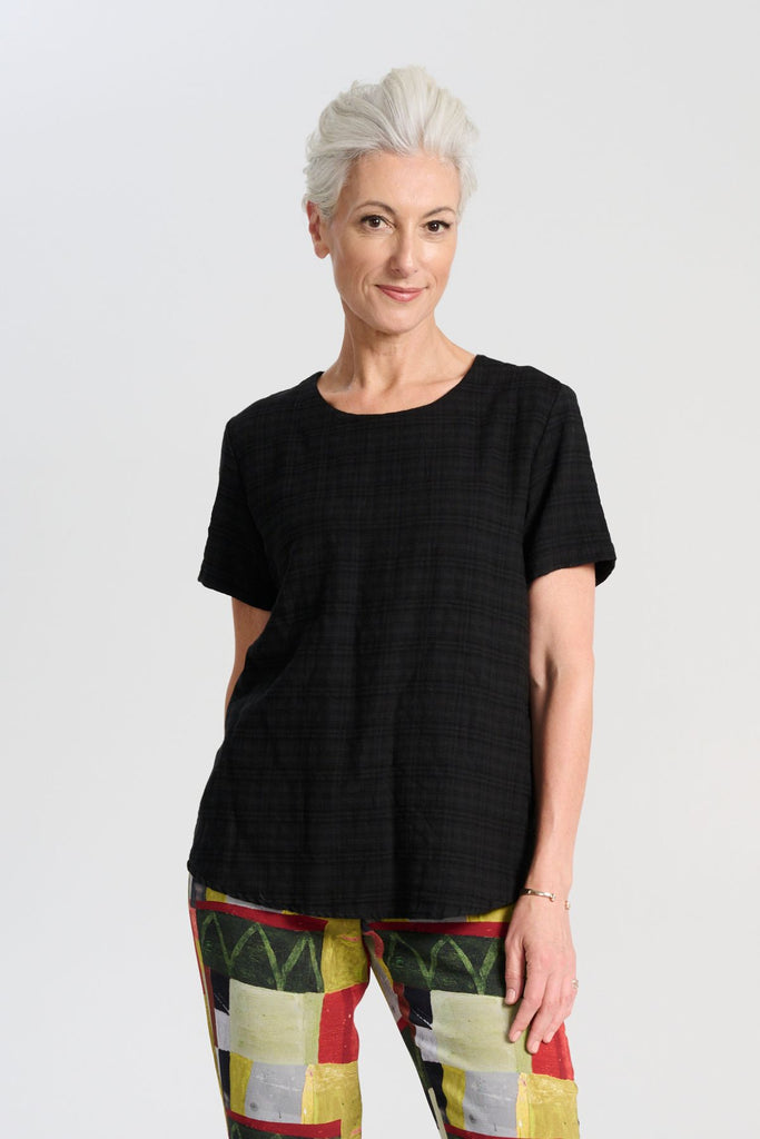 Olga de Polga t-shirt classic top in black brushed cotton seersucker fabric with a subtle check. Short sleeves, round neckline and finishes at the hip. Front view on model.