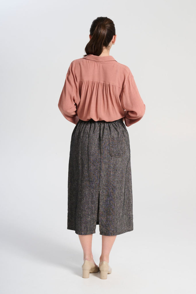 Olga de Polga Hepburn Haven skirt in black Licorice linen fabric. Back elasticated waistband, flat front waistband. Unique front button detail at front waist. Back view on model