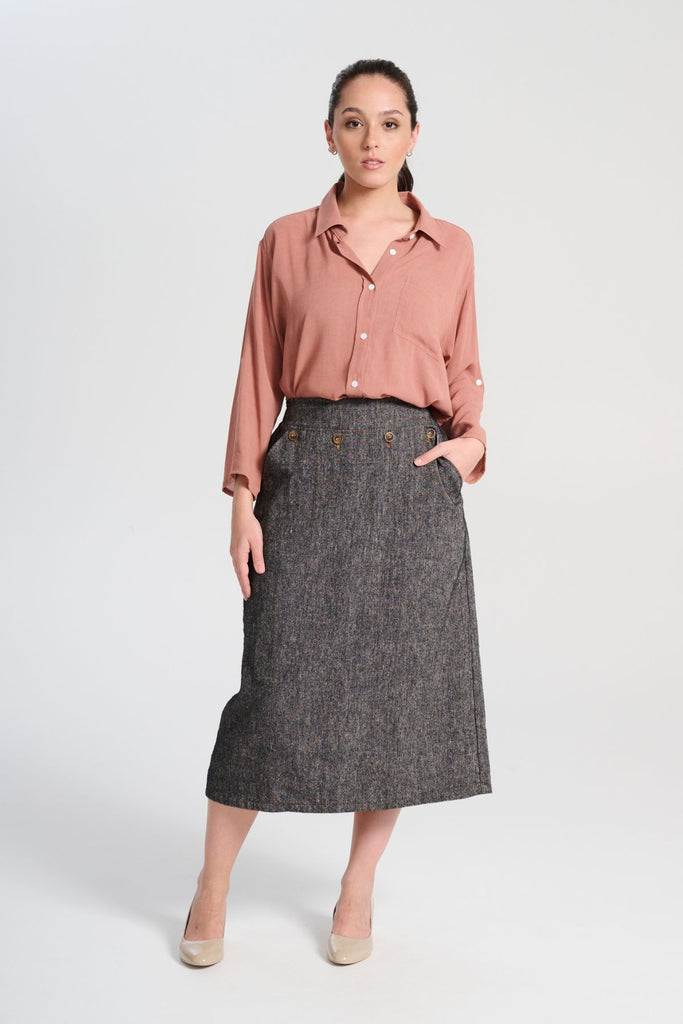 Olga de Polga Hepburn Haven skirt in black Licorice linen fabric. Back elasticated waistband, flat front waistband. Unique front button detail at front waist. Front view on model