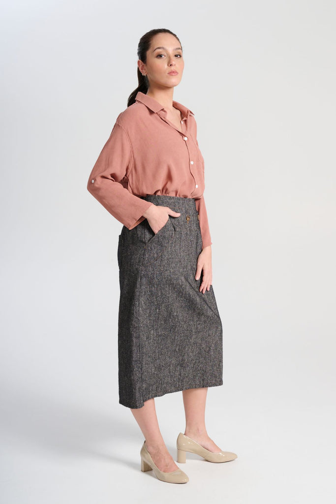 Olga de Polga Hepburn Haven skirt in black Licorice linen fabric. Back elasticated waistband, flat front waistband. Unique front button detail at front waist. Side view on model