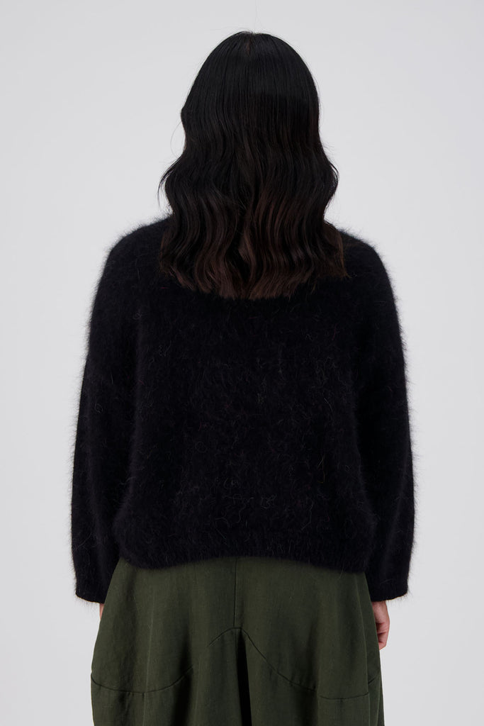 Olga de Polga Montreal Angora Sweater in Black. Our Montreal Angora knits take cosy to a new level. The knit features a ribbed round neckline, drop shoulder and cropped length, so it is perfect with jeans and skirts. The fit is slightly oversized with a boxy cut and long sleeves. Close up back view