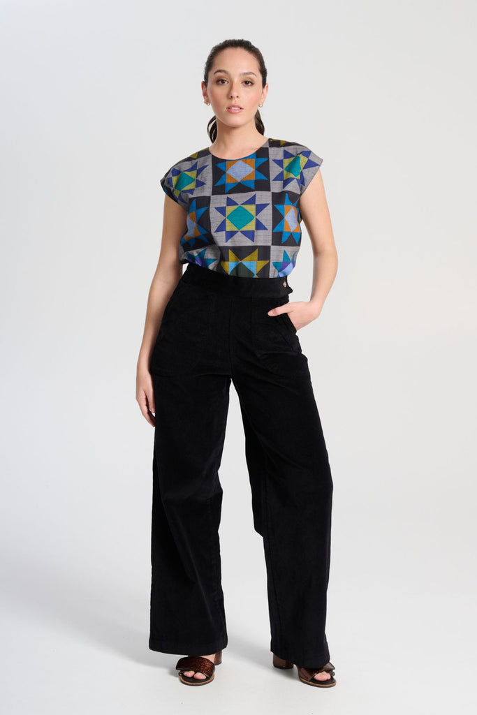Olga de Polga Peggy Paris long pants in soft black cotton velvet. Soft to the touch yet durable, the fabric drapes beautifully while maintaining its shape, making these pants ideal for cooler months. Front view on model.