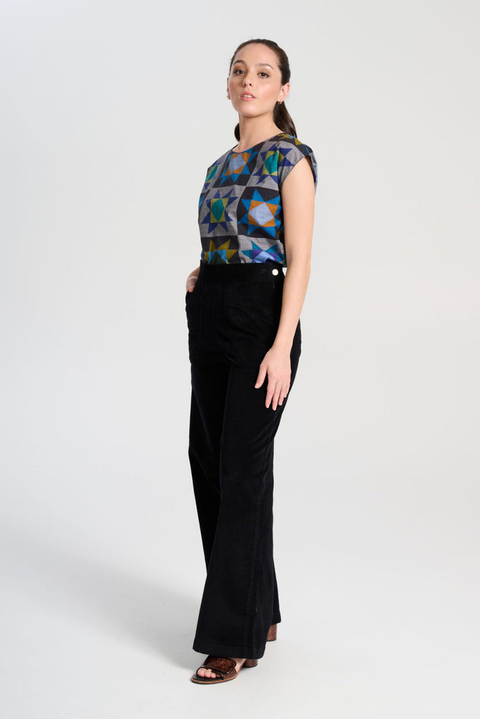 Olga de Polga Peggy Paris long pants in soft black cotton velvet. Soft to the touch yet durable, the fabric drapes beautifully while maintaining its shape, making these pants ideal for cooler months.Side view on  model