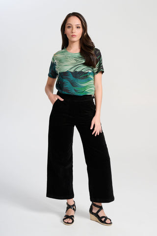 Olga de Polga Peggy Paris cropped wide leg pants in black soft velvet. Soft to the touch yet durable, the fabric drapes beautifully while maintaining its shape, making these pants ideal for cooler months. Front view on model.