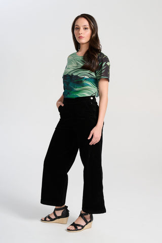 Olga de Polga Peggy Paris cropped wide leg pants in black soft velvet. Soft to the touch yet durable, the fabric drapes beautifully while maintaining its shape, making these pants ideal for cooler months. Side view on model