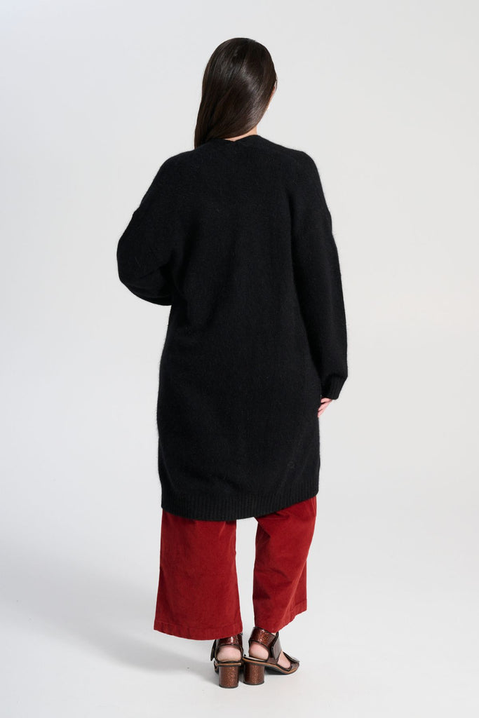 Olga de Polga Black Portofino cardi coat in black angora. Long cardi/coat. Large patch pockets. long sleeves. Back view on model.