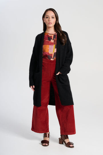 Olga de Polga Black Portofino cardi coat in black angora. Long cardi/coat. Large patch pockets. long sleeves. Front view on model.