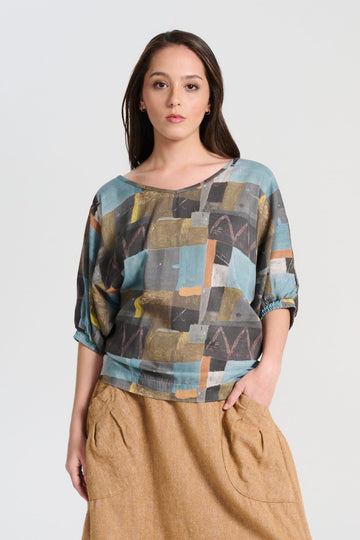 Olga de Polga Azure blue soft wash Camisa blouse in 100% Tencel. A reversible top with a soft v-neck on one side and a round neck on the other side. 
 Half sleeves, with a batwing shape. Front view on model.