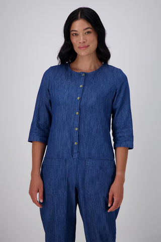 Olga de Polga Blue mid-wash denim Artisan Jumpsuit in cotton denim. Half sleeves and a button down front with patch pockets. Ankle length. Front close up of upper body on model.