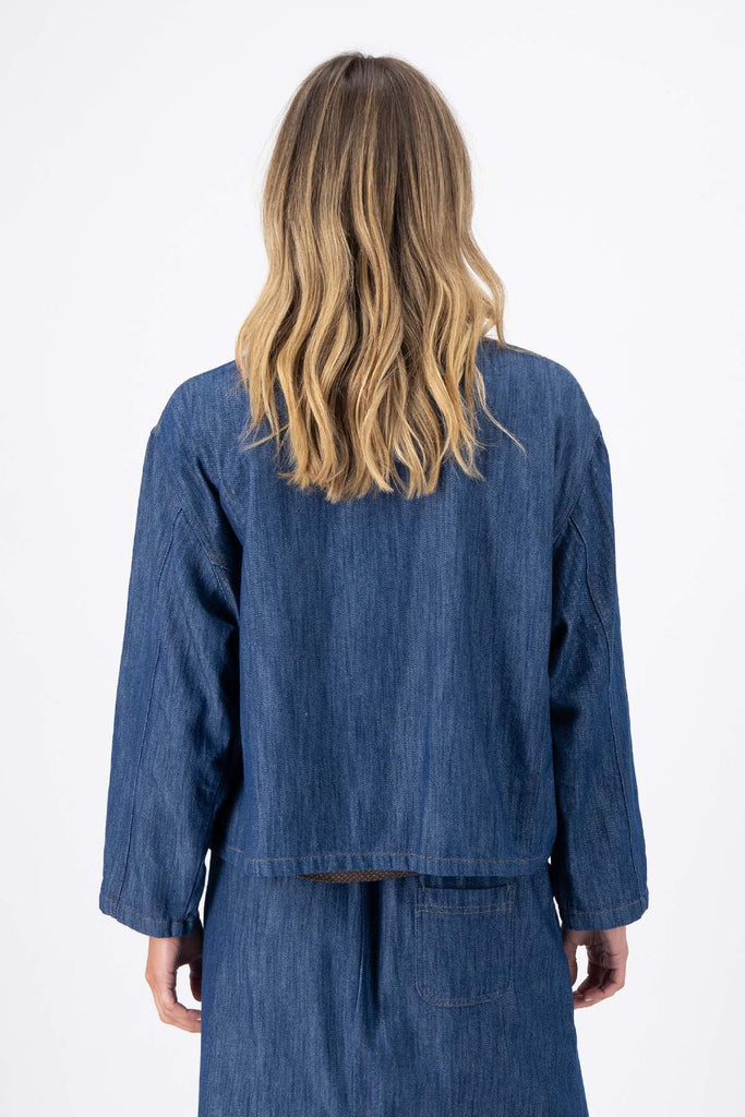 Olga de Polga Mid-Wash denim Billie jacket. Front patch pockets. Oversized boxy fit. Button down front. Full length sleeves. Back close-up view on model.