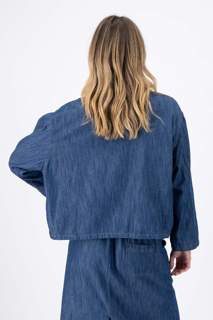 Olga de Polga Mid-Wash denim Billie jacket. Front patch pockets. Oversized boxy fit. Button down front. Full length sleeves. Back view on model.