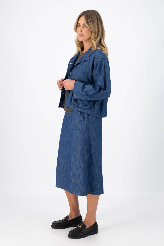 Olga de Polga Mid-Wash denim Billie jacket. Front patch pockets. Oversized boxy fit. Button down front. Full length sleeves. Side view on model.