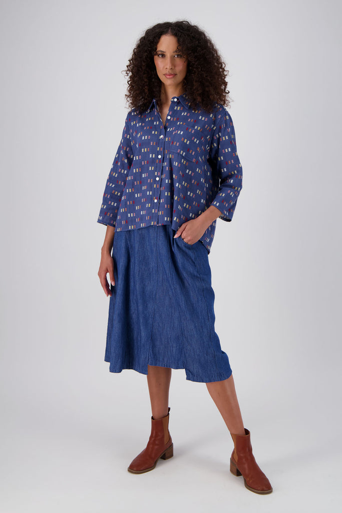 Olga de Polga classic shirt in the new Blue Telegraph woven cotton. With accents of red, yellow, cream and mauve. Front full length view on model