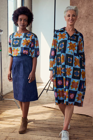 The blouse features a beautifully detailed lantern sleeve with a drop shoulder and delicate pleating on the shoulder and cuff. It also has a wide boat neckline and invisible zip fastening at the back. Front view of two models.