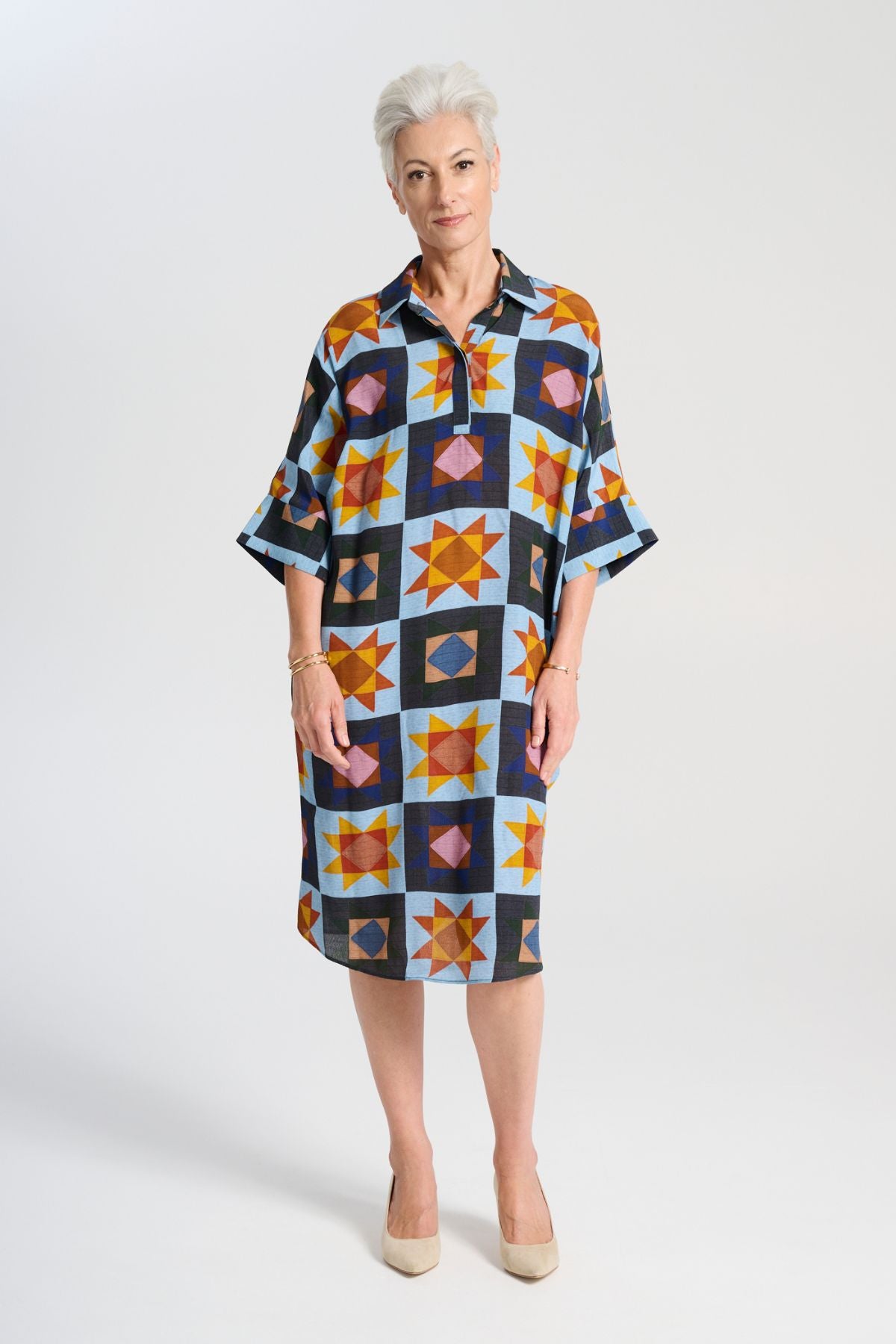 Olga de Polga Estilo shift dress in the Veda Day blue print. Classic shift silhouette with a flattering collar and half sleeves.Front button opening at neckline.Slouchy batwing sleeves.Finishes at the knee, depending on height. Front view on model