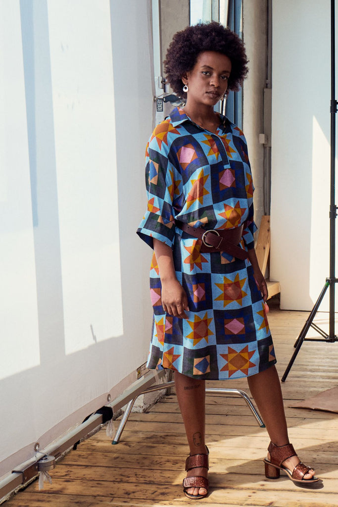 Olga de Polga Estilo shift dress in the Veda Day blue print. Classic shift silhouette with a flattering collar and half sleeves.
Front button opening at neckline.
Slouchy batwing sleeves.
Finishes at the knee, depending on height.  Side front view on a model styled with a belt.
