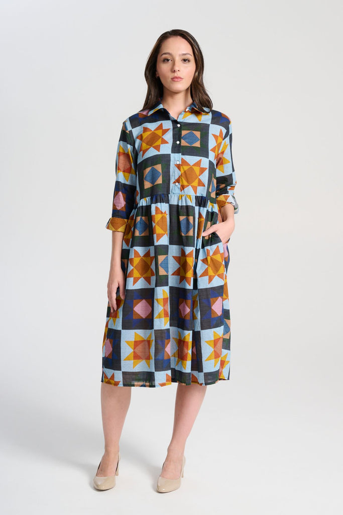 Olga de Polga Sienna dress in printed Veda Day cotton voile. The Sienna Dress is a long-sleeve version of our classic Villa dress, perfect for cooler days or those who prefer arm coverage. Designed with a relaxed, loose fit, it features a collar and button-front opening, leading to a gathered waist for added shape. The full-length sleeves have cuff and button closures, offering the option to roll them up for a more casual look. Front view on model