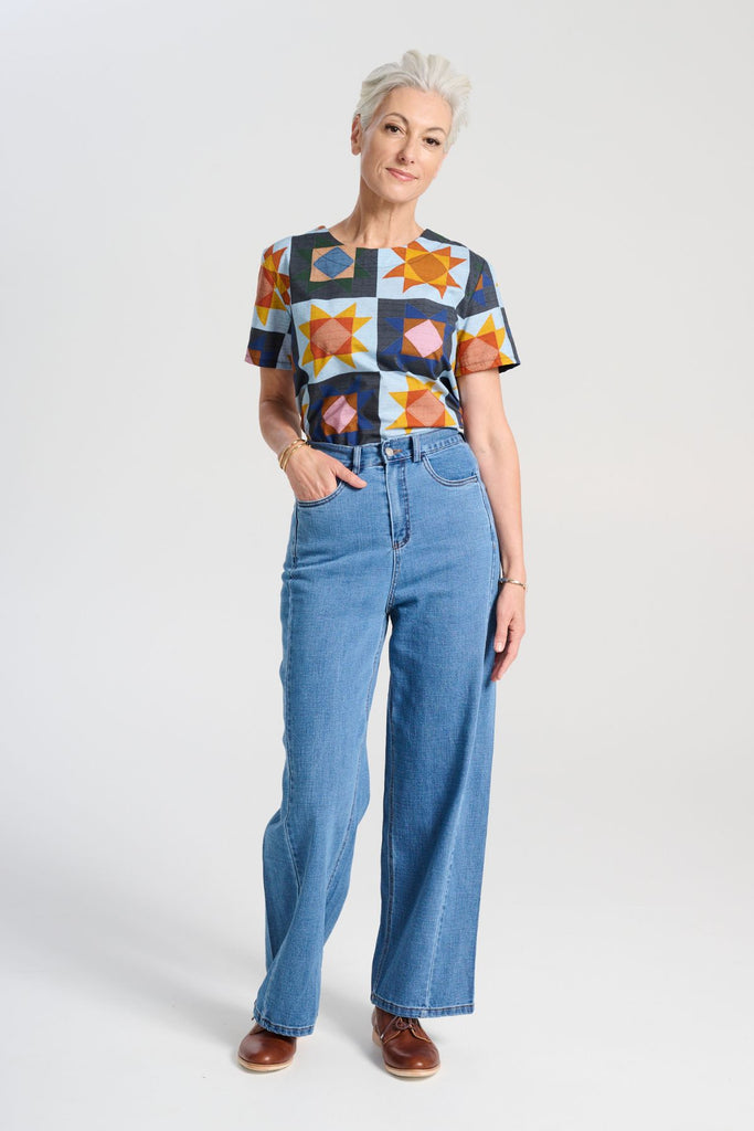 Olga de Polga Veda Day Top in printed cotton. Light blue background with geometric shapes. Round neckline, Short sleeves. Full length view on model