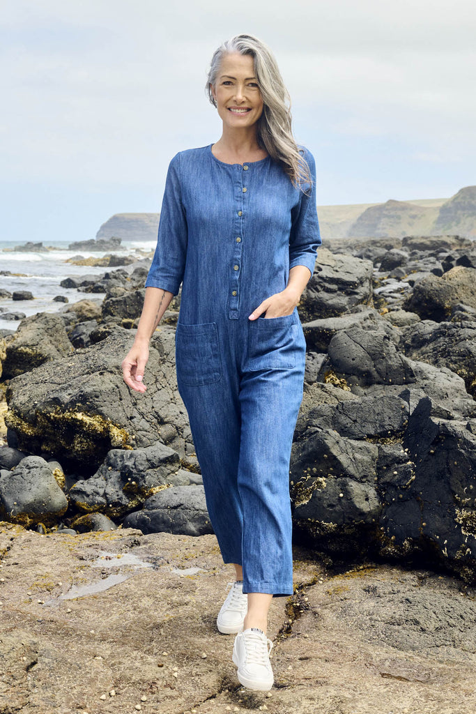 Olga de Polga Blue mid-wash denim Artisan Jumpsuit in cotton denim. Half sleeves and a button down front with patch pockets. Ankle length. Front view on model