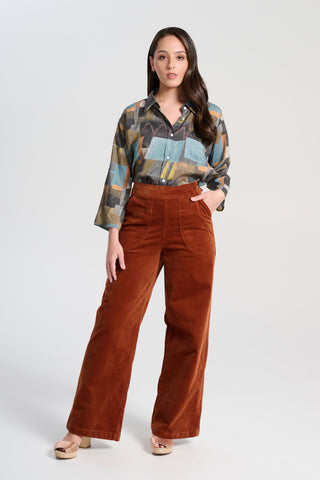 Olga de Polga Peggy Lou long pants in Caramel velvet corduroy. Crafted from a luxurious blend of 97% cotton and 3% spandex, our Velvet Corduroy offers the perfect balance of structure and softness.  Front view on model.
