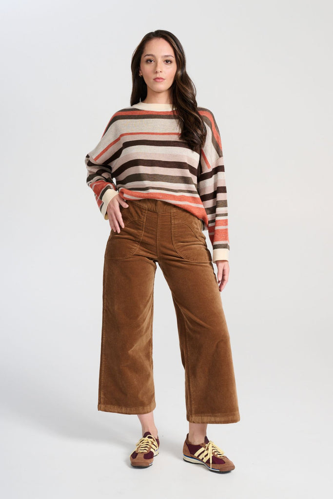 Olga de Polga Brown Earth Colorado Knit sweater with stripes in earthy colours of cream, coral, beige and brown. Long sleeves, dropped shoulders, round neckline. Front full length view on model.