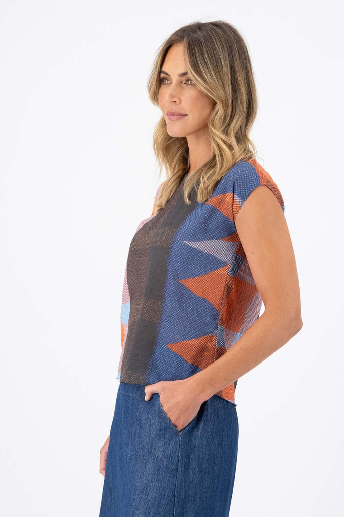 Olga de Polga Tee in Jada printed cotton seersucker. Shades of brown, red, pink and blue, and orange are all part of the Jada print. Side view on model.