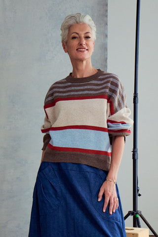 Olga de Polga Brown Paloma Sweater. A striped sweater with browns, cream, red and pale blue. Front view on model