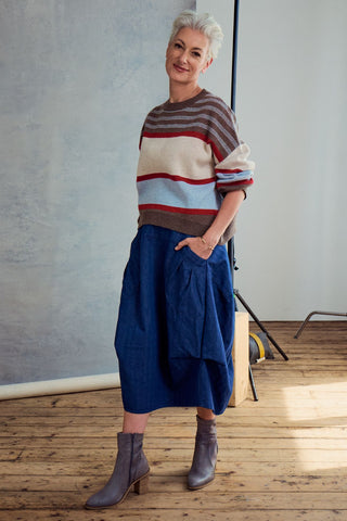 Olga de Polga Brown Paloma Sweater. A striped sweater with browns, cream, red and pale blue. Side front full length view on model