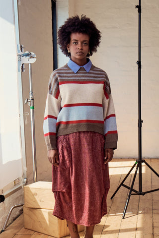 Olga de Polga Brown Paloma Sweater. A striped sweater with browns, cream, red and pale blue. Front close up view on model