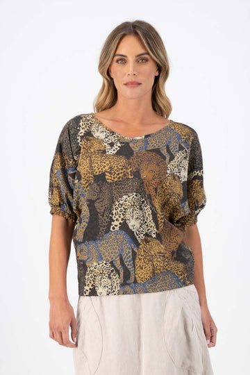 Olga de Polga Camisa blouse in Sabana printed fine Tencel. Reversible top with a soft v-neck on one side and a boatneck on the other. Half sleeves. Tapers in at the waist. Front view on model.