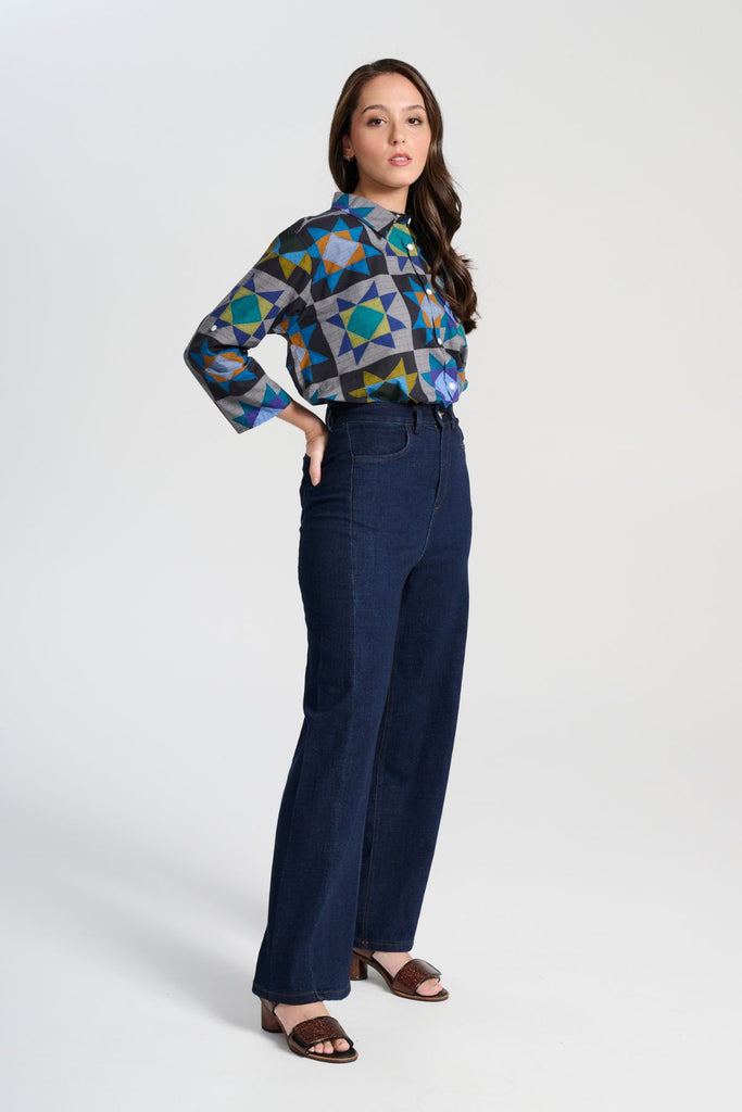 Olga de Polga Veda Shirt in Night printed cotton. Front view on model. It has an effortlessly chic, relaxed silhouette that drapes with ease. Leave it loose or tuck it in - the choice is yours.
The front of the shirt sits at the waist while the back falls to the hips for a lovely drape. Side full length view on model.