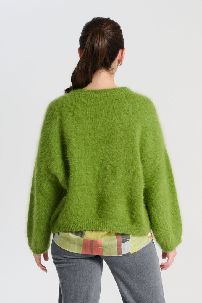 Olga de Polga angora knit sweater in Apple Green. The knit features a ribbed round neckline, drop shoulder and cropped length, so it is perfect with jeans and skirts. The fit is slightly oversized with a boxy cut and long sleeves. Back view on model
