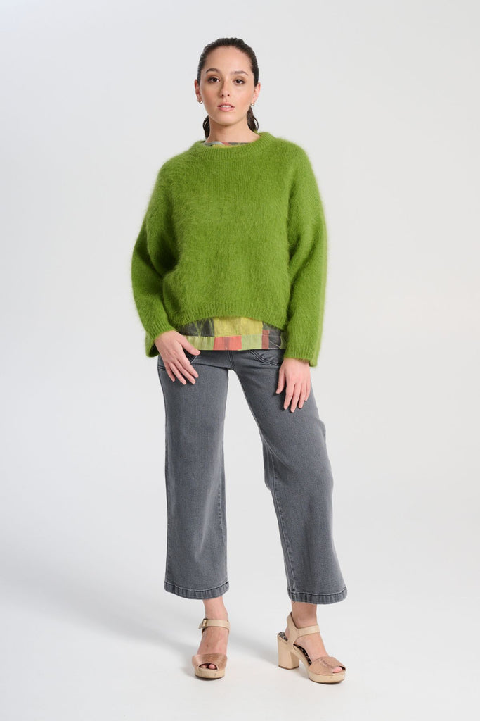 Olga de Polga angora knit sweater in Apple Green. The knit features a ribbed round neckline, drop shoulder and cropped length, so it is perfect with jeans and skirts. The fit is slightly oversized with a boxy cut and long sleeves. Front full length view on model