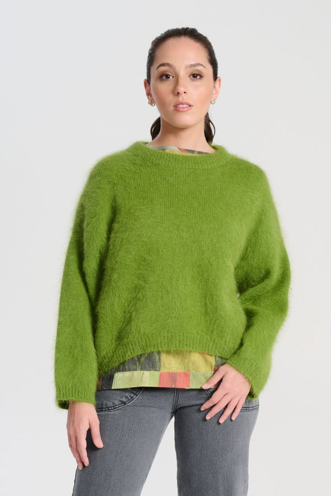 Olga de Polga angora knit sweater in Apple Green. The knit features a ribbed round neckline, drop shoulder and cropped length, so it is perfect with jeans and skirts. The fit is slightly oversized with a boxy cut and long sleeves. Front view on model