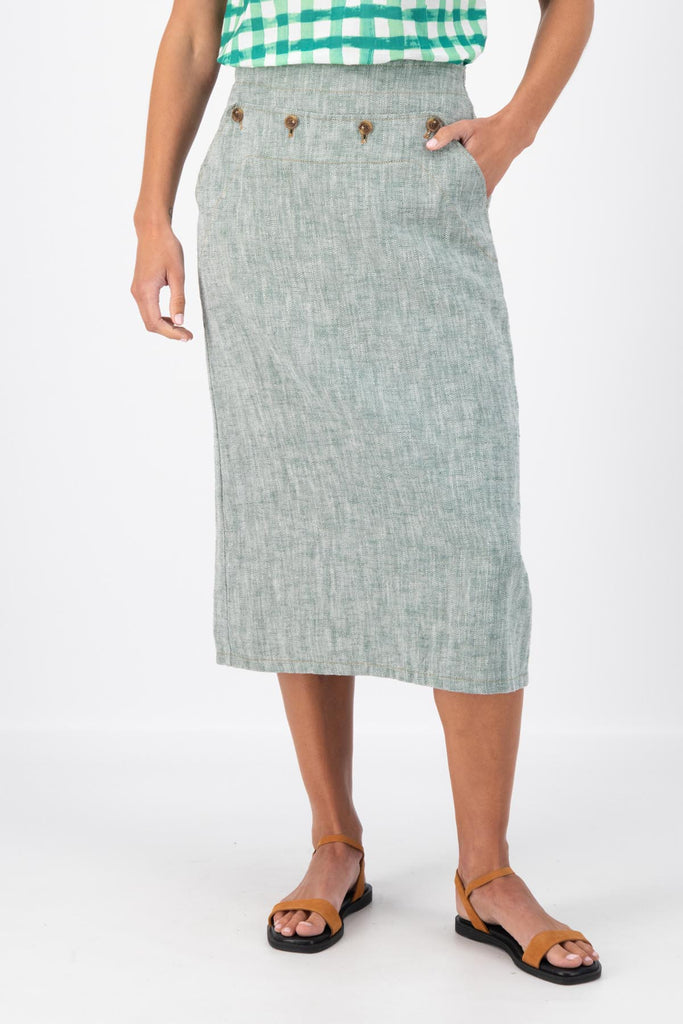 Olga de Polga Green Hepburn skirt in herringbone linen. A pencil skirt with a twist.  Featuring a unique button detail at the waist that forms a flattering pocket shape, this skirt adds personality to any outfit. With an elasticated back waist for comfort, it finishes just below the knee and has a stylish back split for ease of movement. Front close-up view on model.